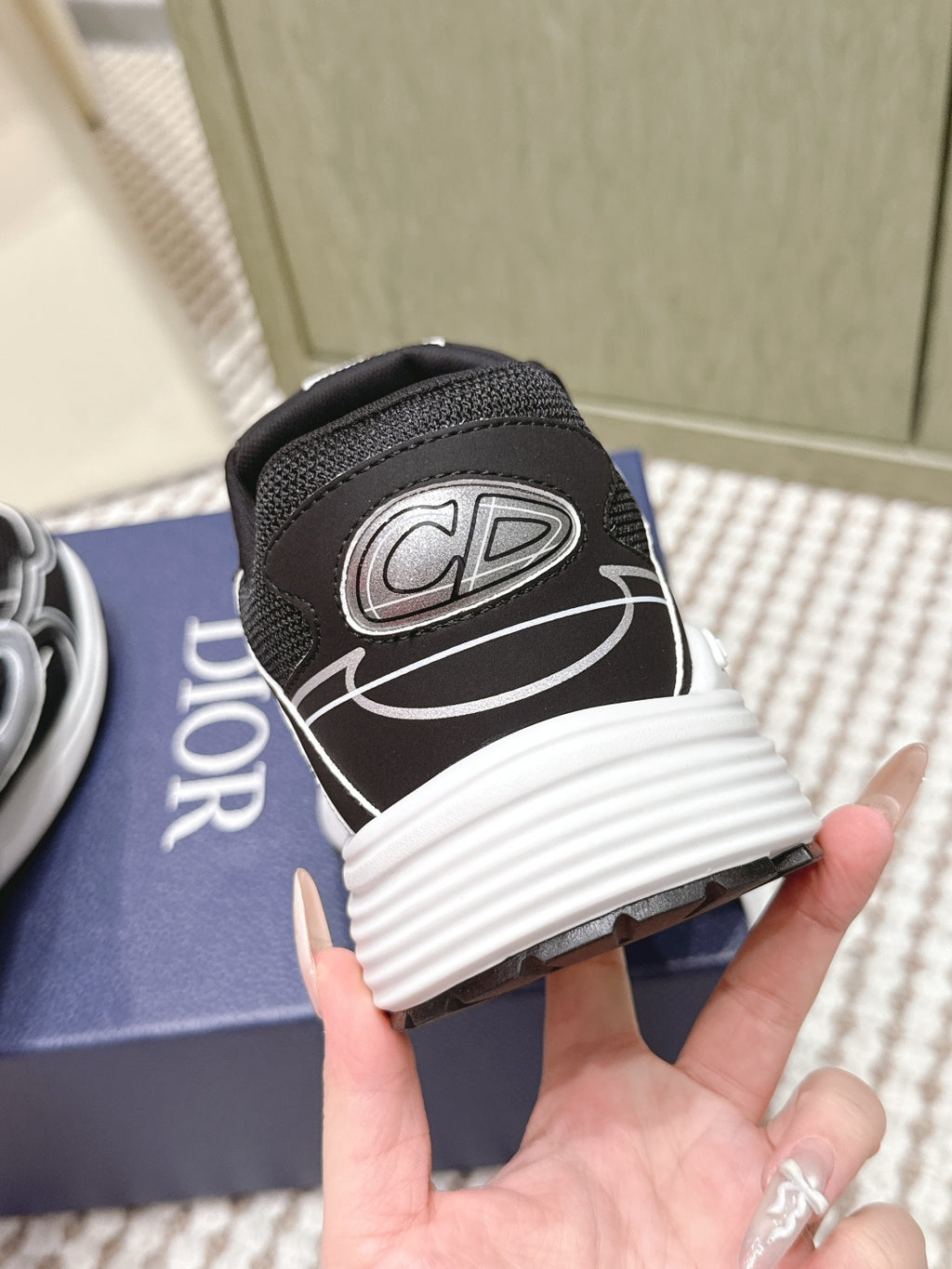 Black Dior unisex sneaker heel close-up, CD logo patch and white sole