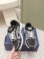 Black and white Dior unisex sneakers close-up with hand, front view
