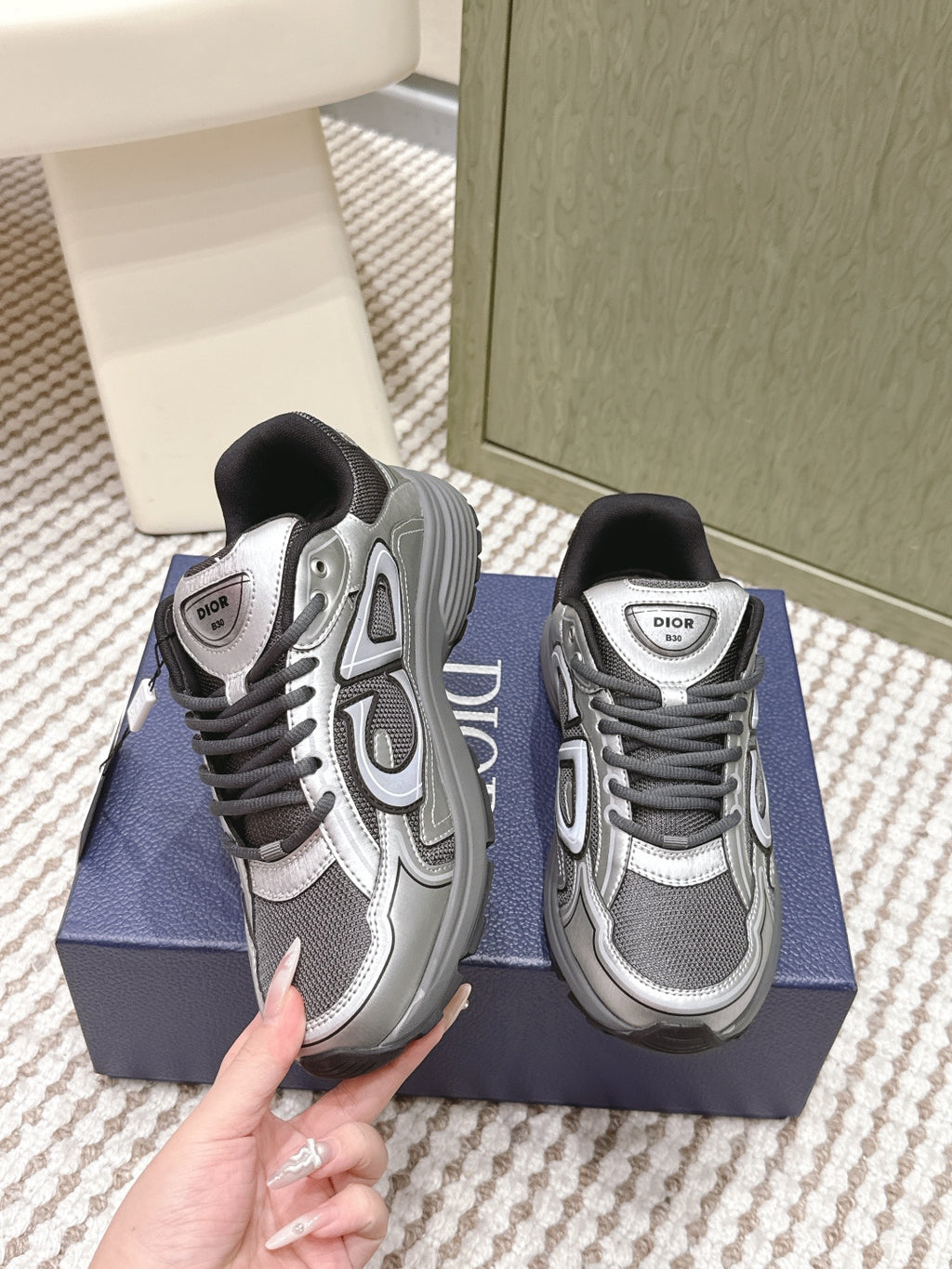 Grey Dior sneakers with black collar, front and side lace eyelets visible