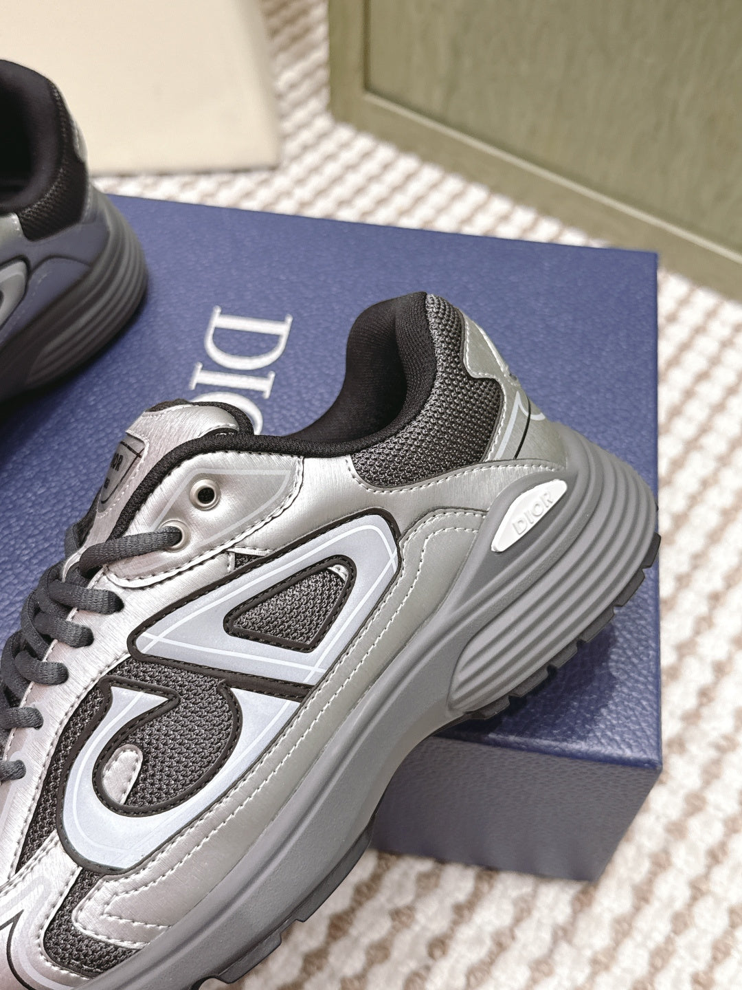 Dior sneakers close-up, grey and silver with ribbed rubber sole and lace-up front