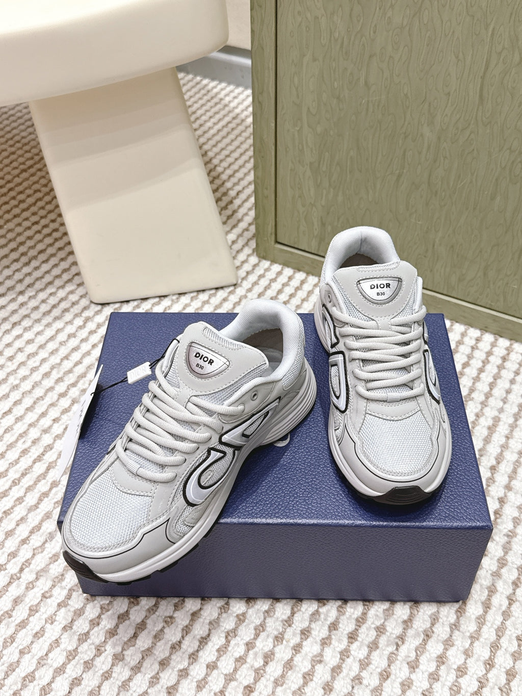 Unisex lace-up sneakers in light gray/white, angled view showing side panels and laces