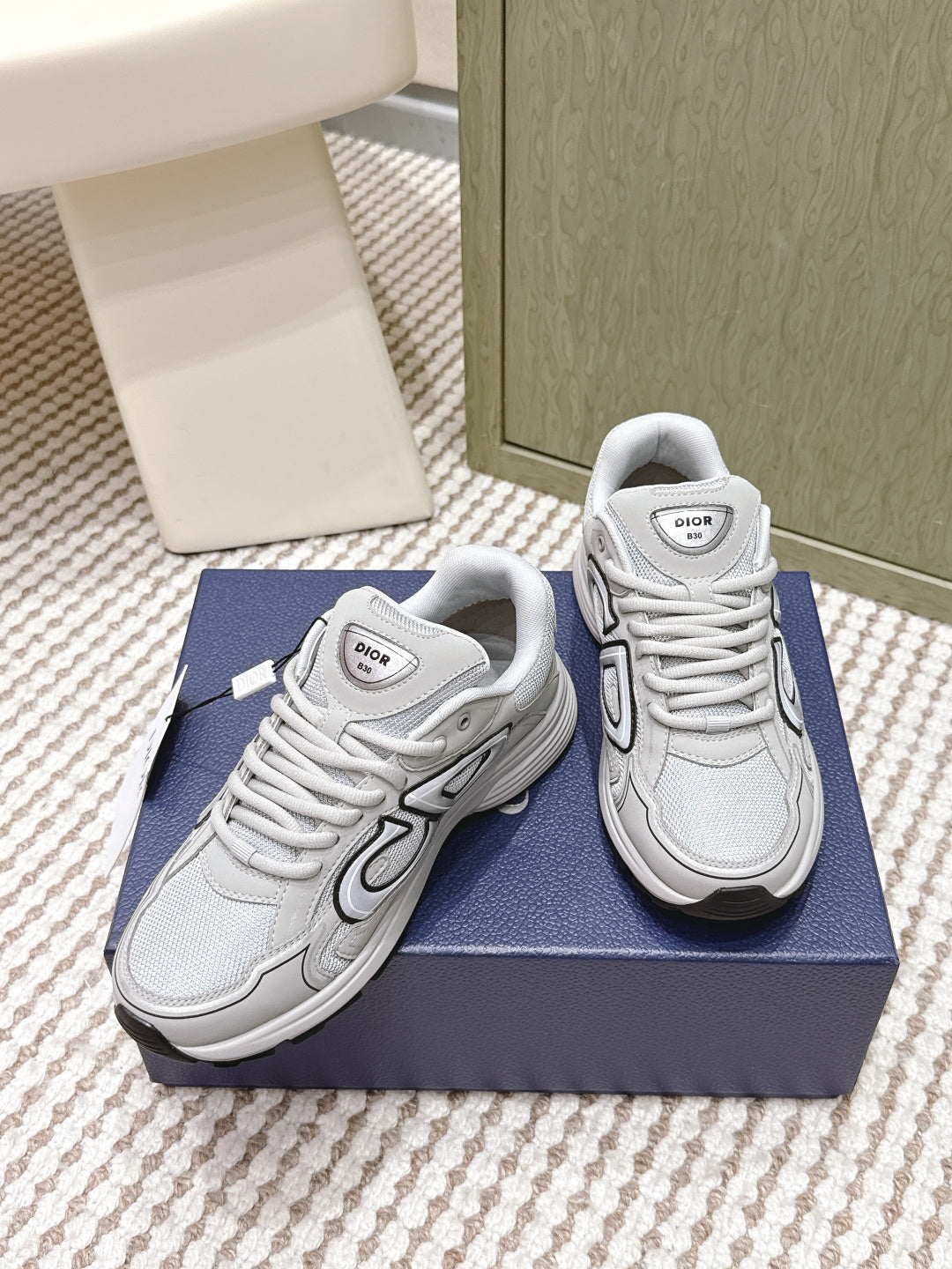 Unisex lace-up sneakers in light gray/white, angled view showing side panels and laces