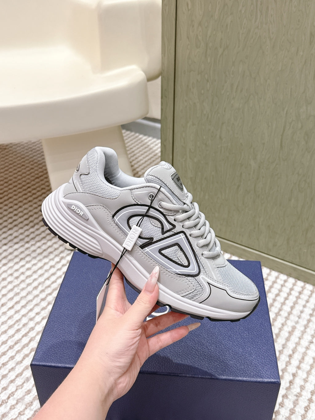 Unisex lace-up sneakers in light gray/white with sporty tread sole, held near side
