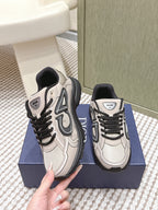 Pair of unisex low-top sneakers, light beige and black, viewed from side