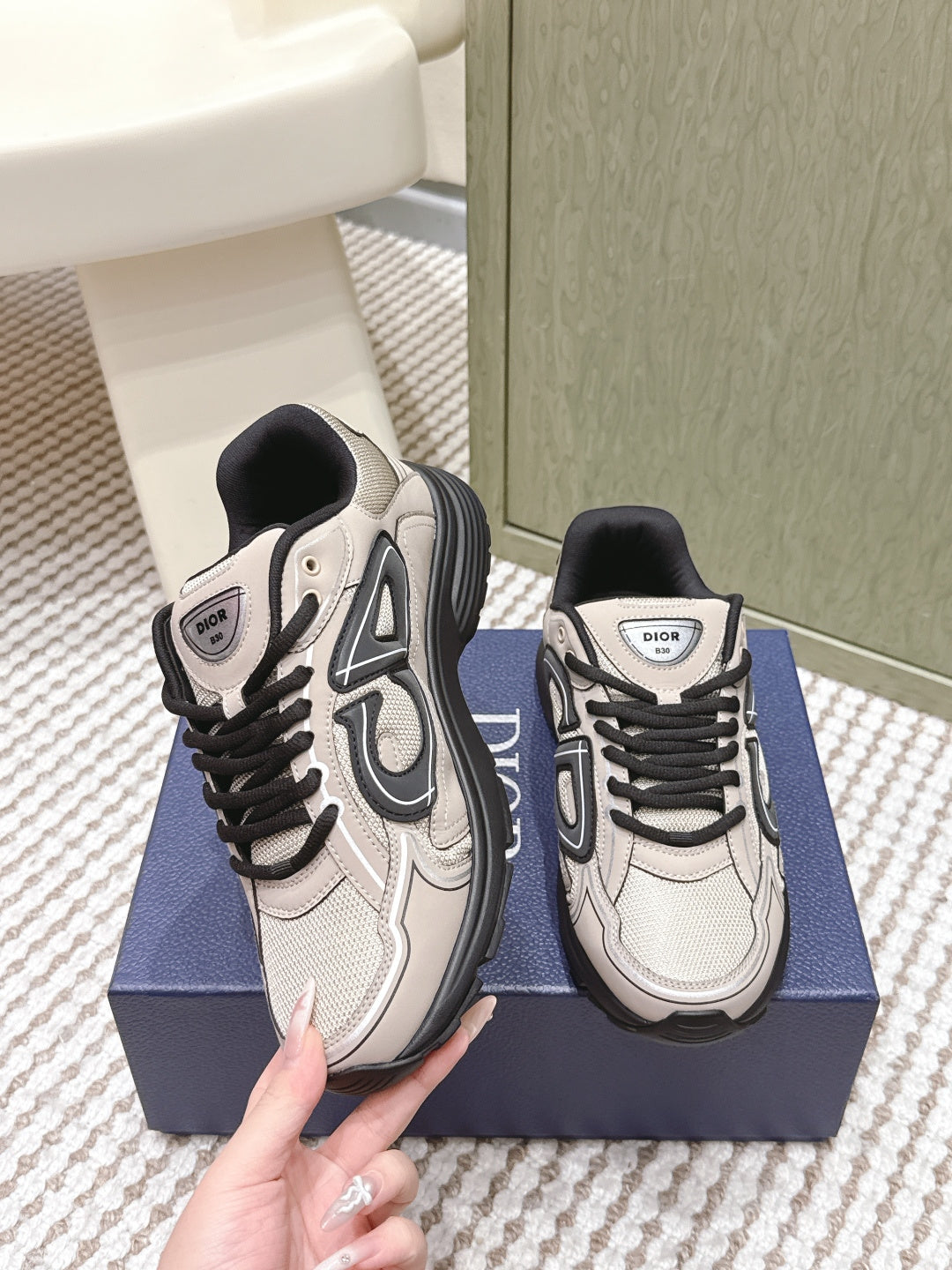 Pair of unisex low-top sneakers, light beige and black, viewed from side