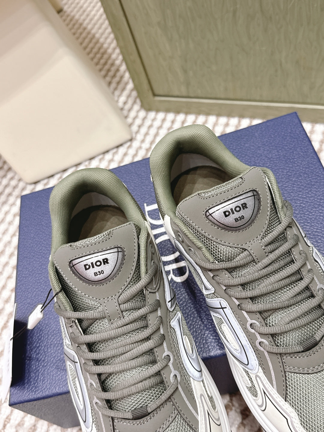 Close-up of grey sneakers with Dior logo tongue labels and white soles