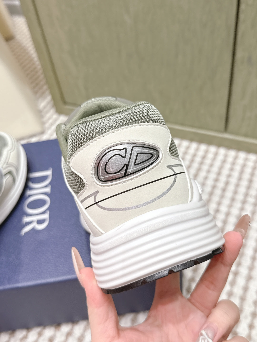 Grey sneaker heel view with CD emblem patch and white ribbed sole