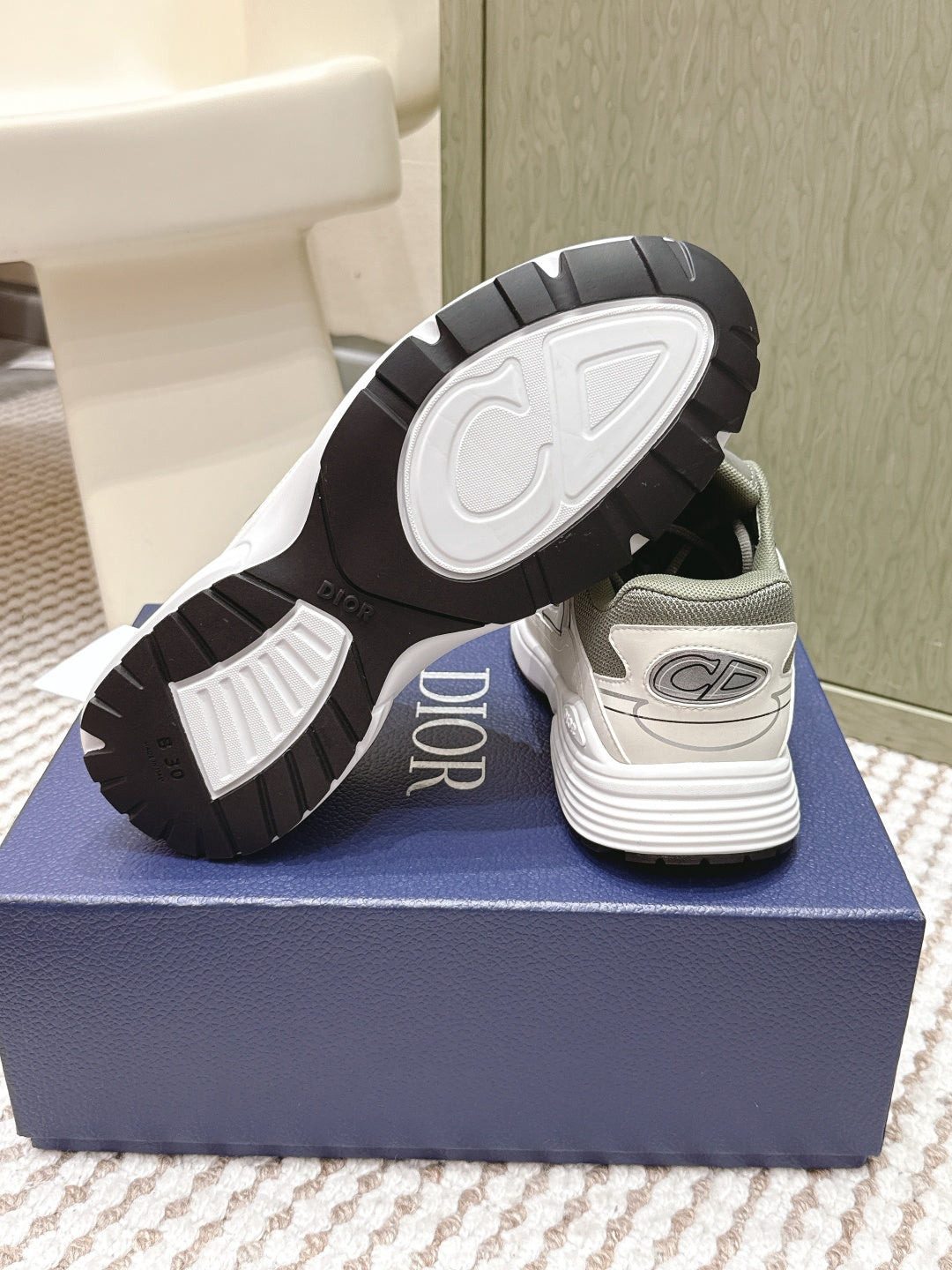 Sneakers with outsole and heel view, white treaded sole on the box