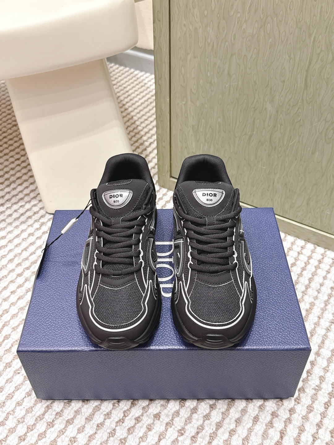 Black lace-up sneakers with white paneling and Dior logo patch