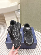 Black lace-up sneakers with white stitched overlays and Dior branding on tongue