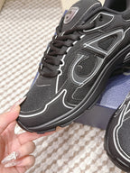 Black lace-up sneaker side close-up with white stitching and Dior logo tongue patch