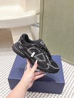 Black lace-up sneakers, side profile with white accents and thick textured sole