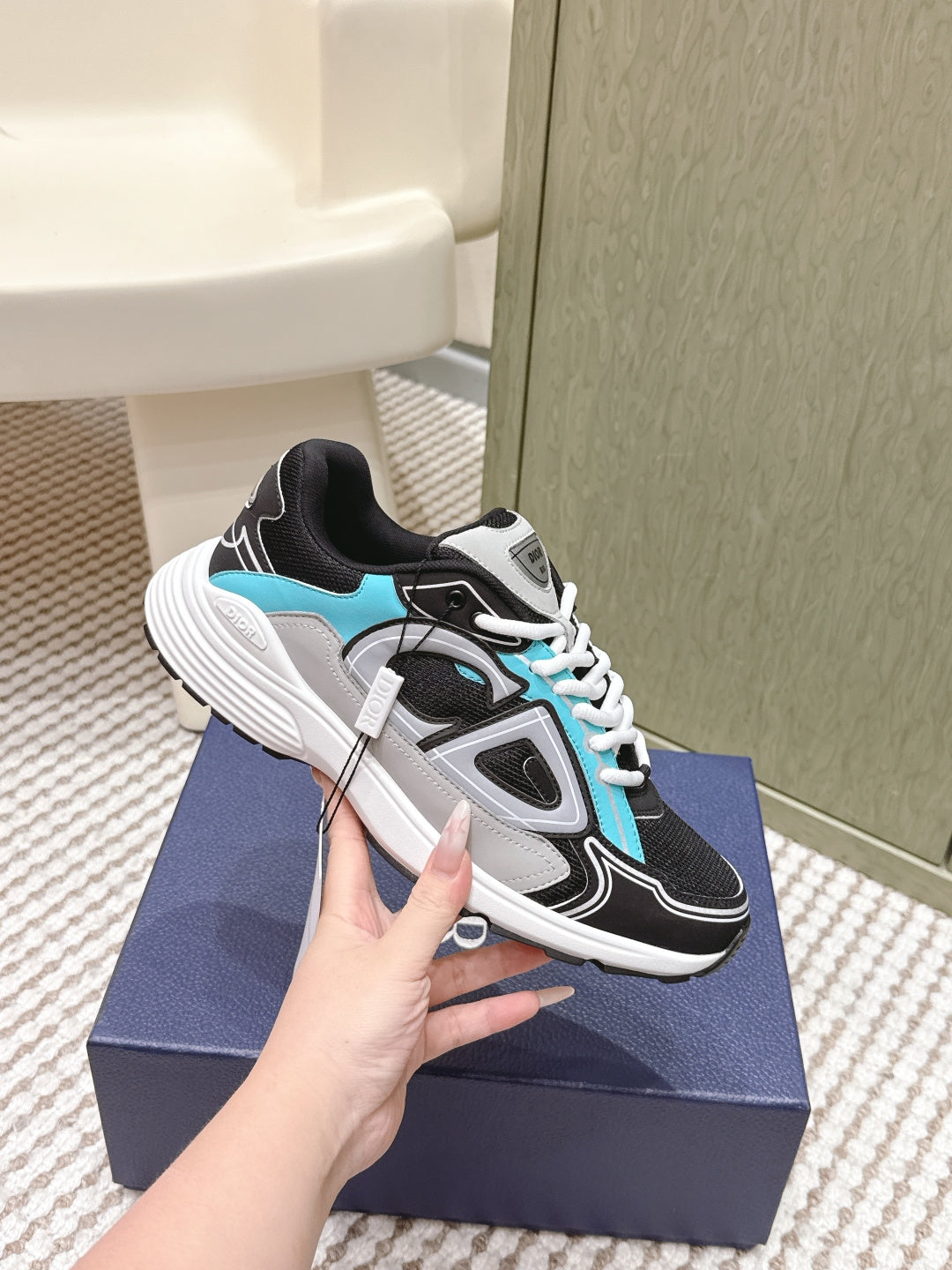 Dior unisex sneakers, side view with black, white, and turquoise panels and laces