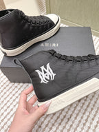 Amiri black sneaker with white logo patch and white textured rubber midsole