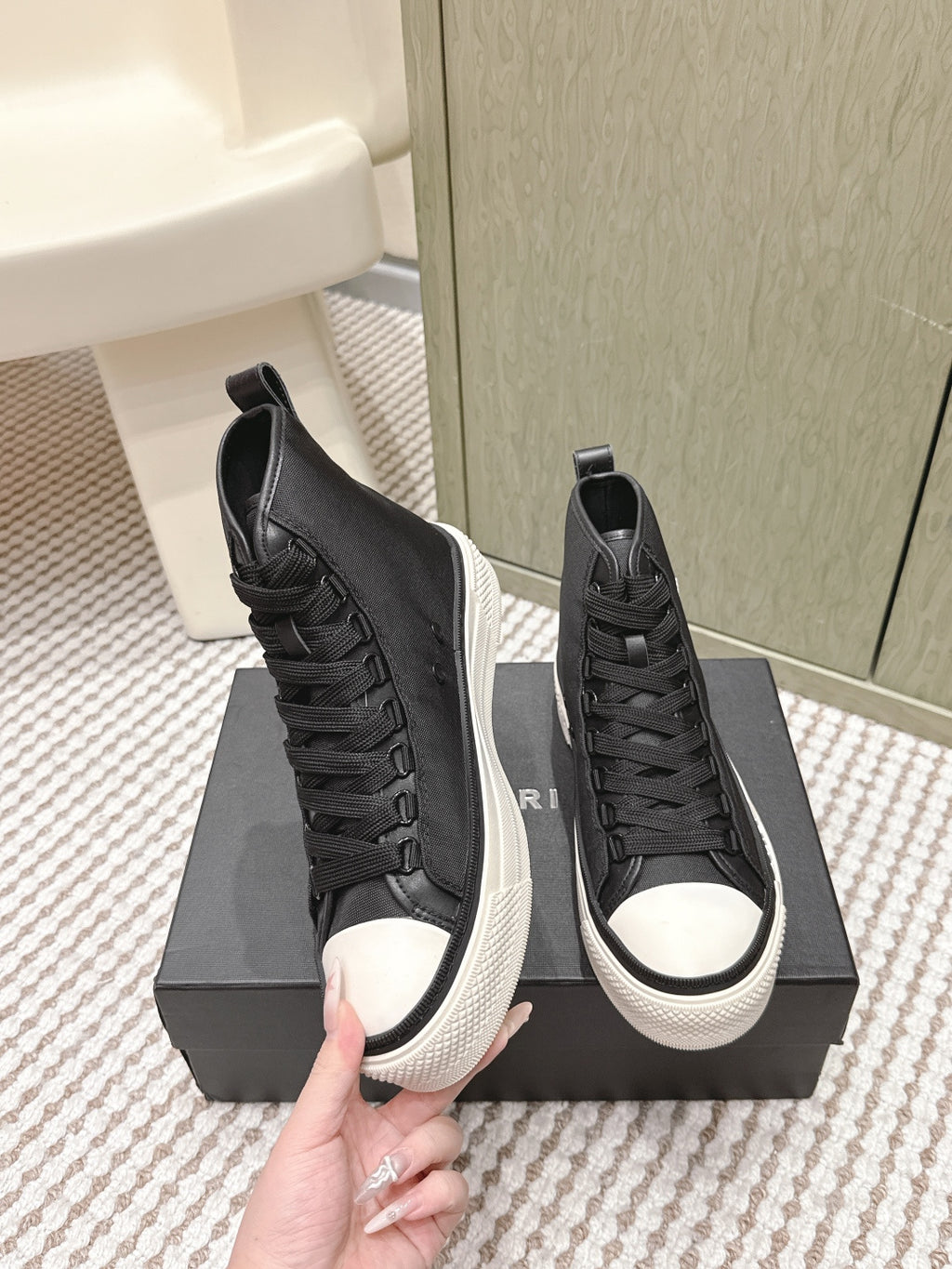 Amiri black high-top sneakers with textured uppers, lace-up closure, and white soles