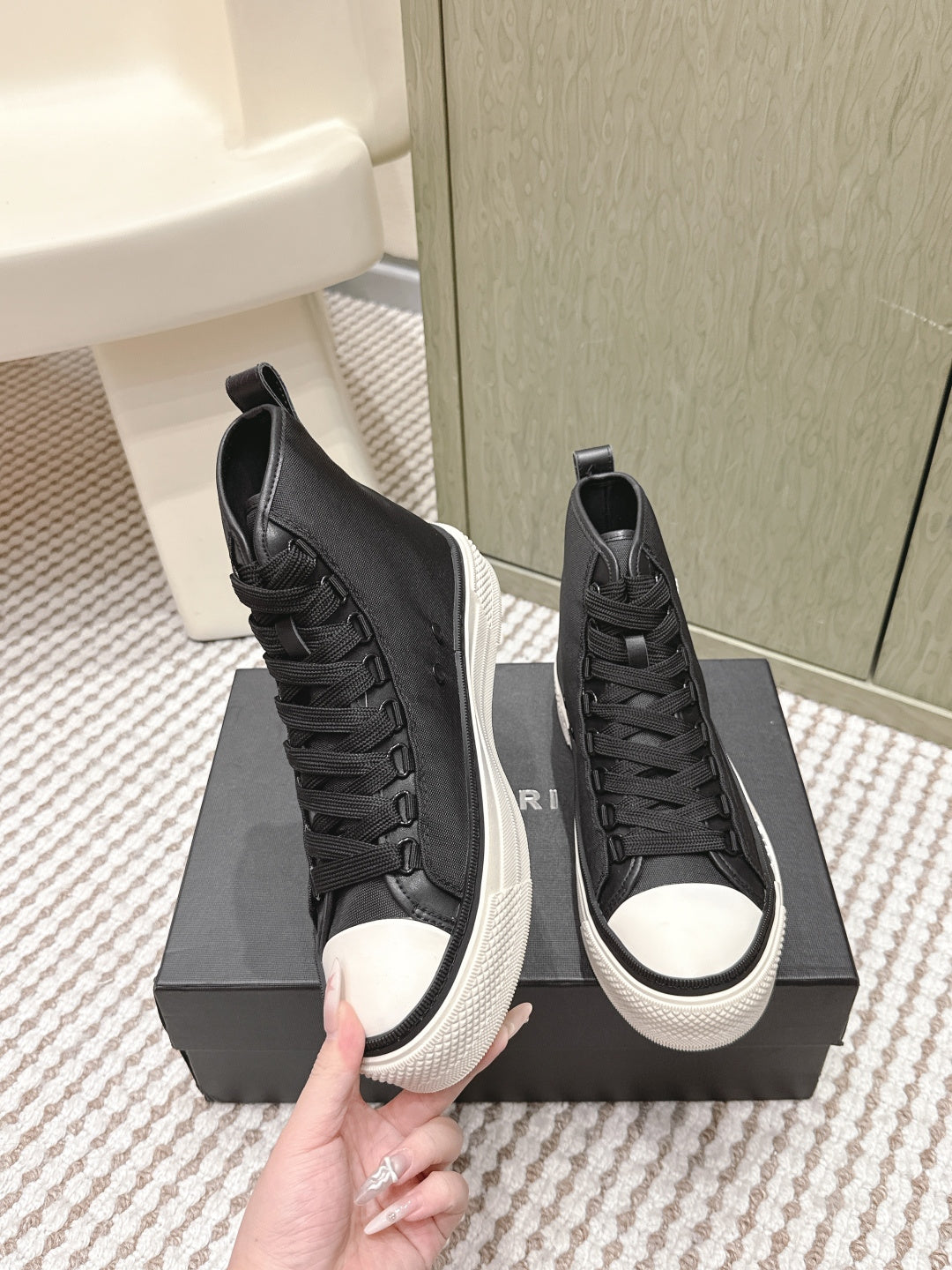Amiri black high-top sneakers with textured uppers, lace-up closure, and white soles