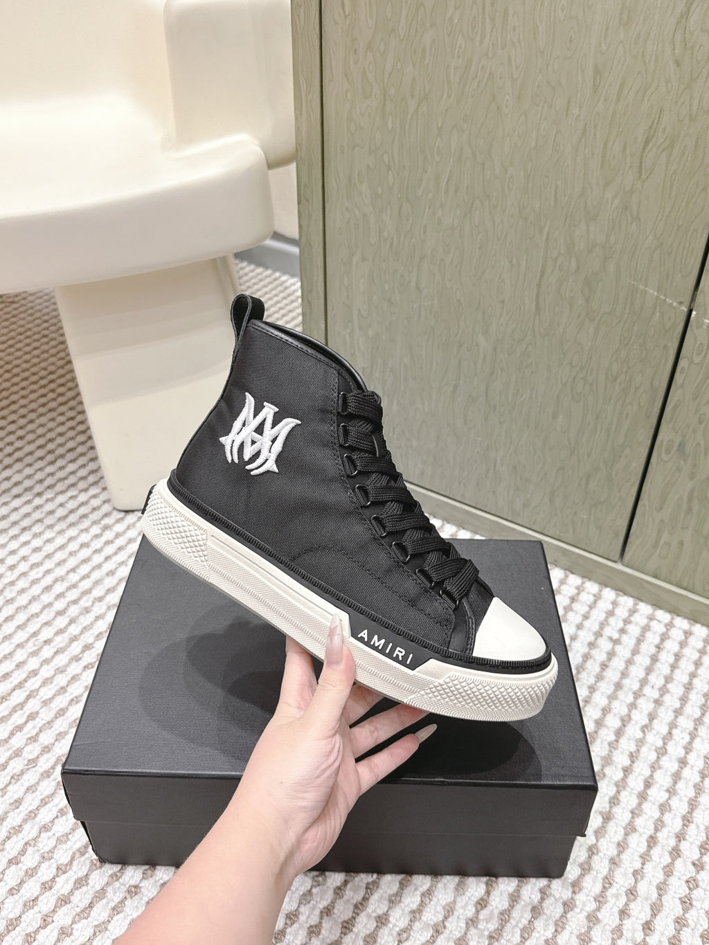 Amiri black high-top sneakers with large white logo on the side and white rubber sole