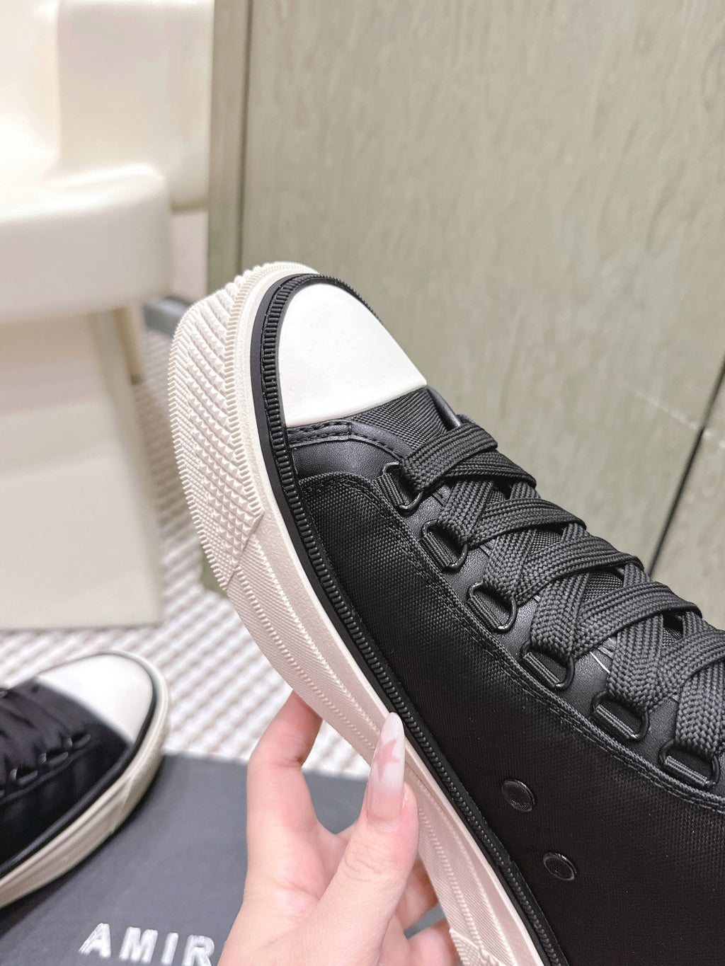 Amiri black lace-up sneaker with side stitching, white sole trim, and rubber toe cap
