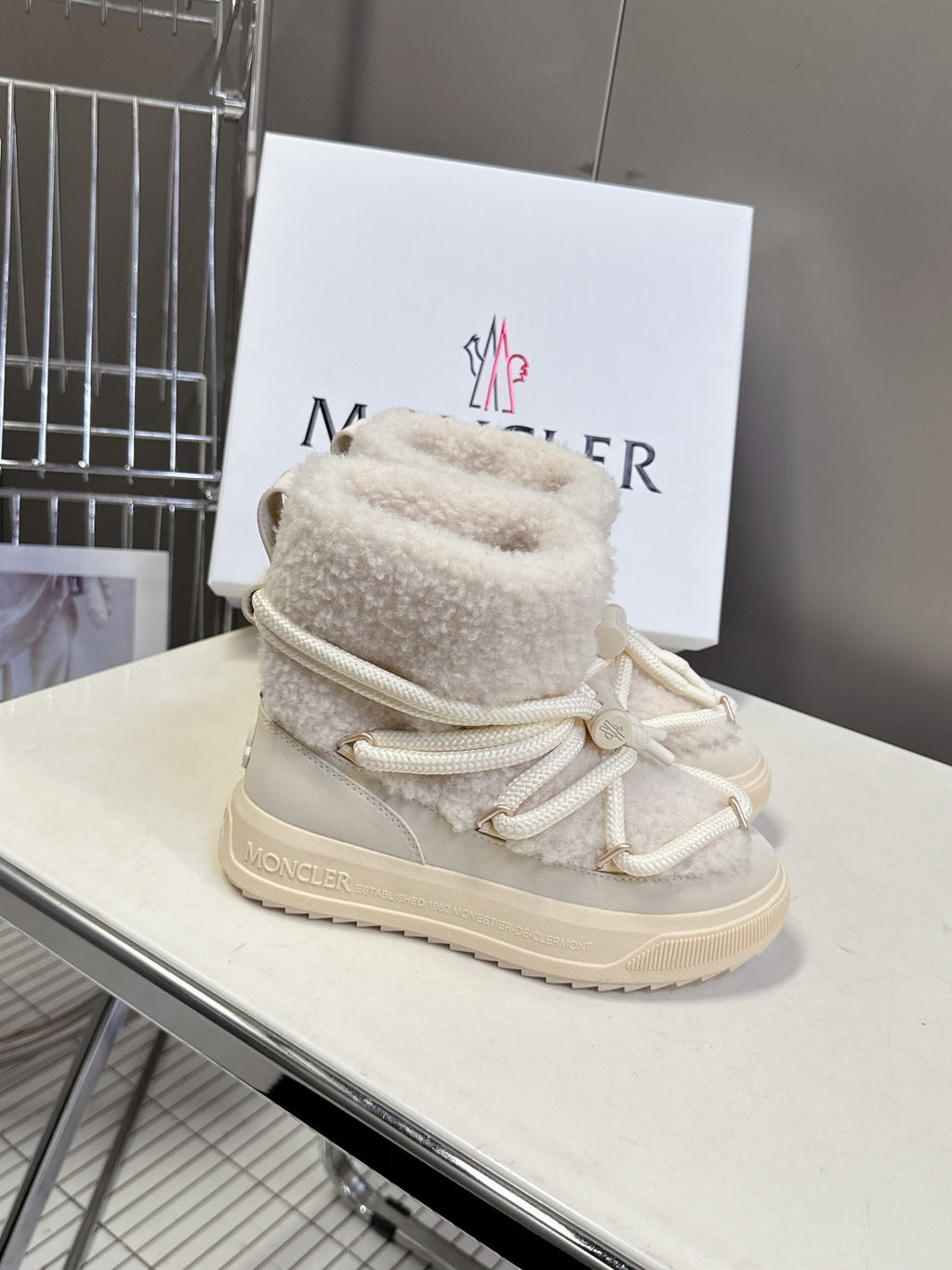 Cream high-top lace-up shoes with sherpa lining, white laces, and chunky sole