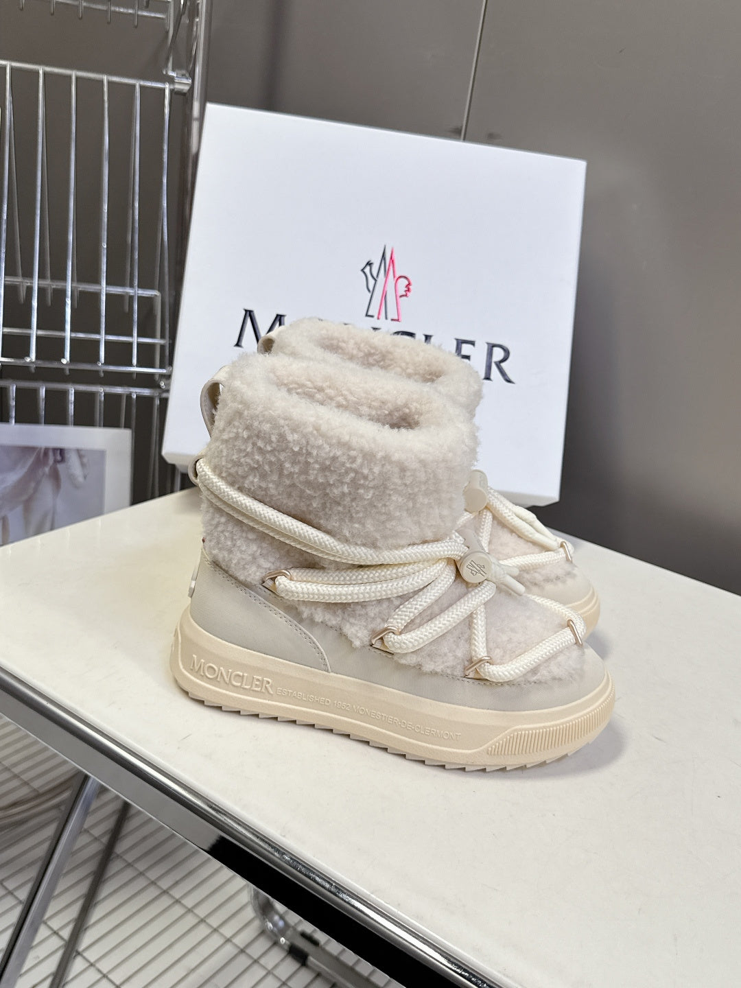 Cream high-top lace-up shoes with sherpa lining, white laces, and chunky sole