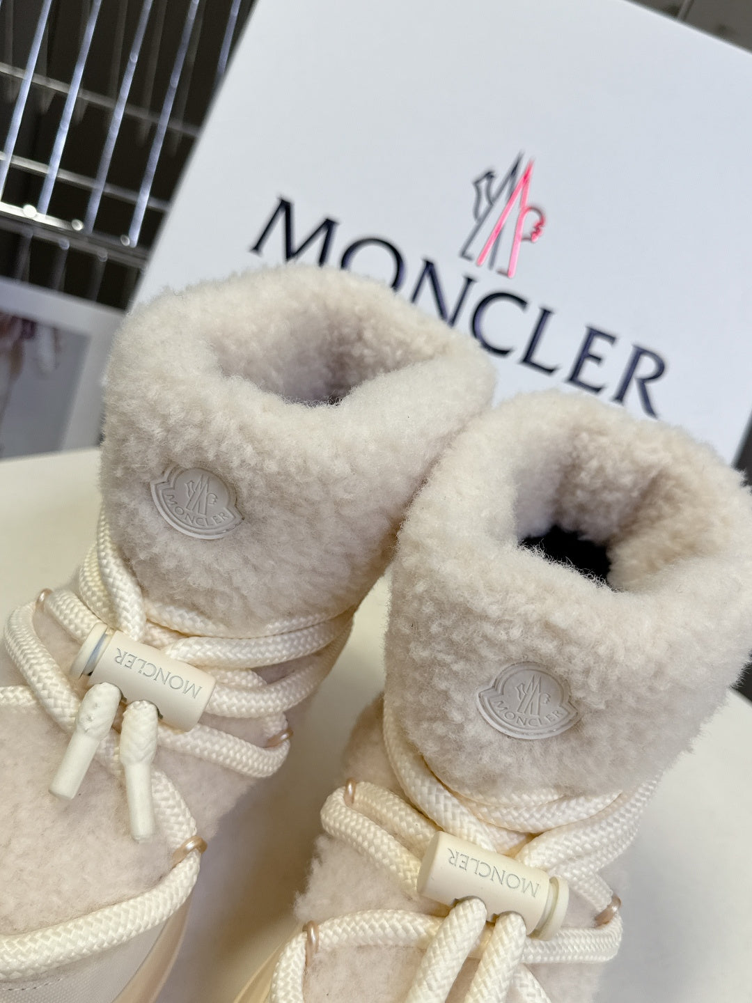 Cream fur-lined ankle sneakers with white laces and stitched eyelets