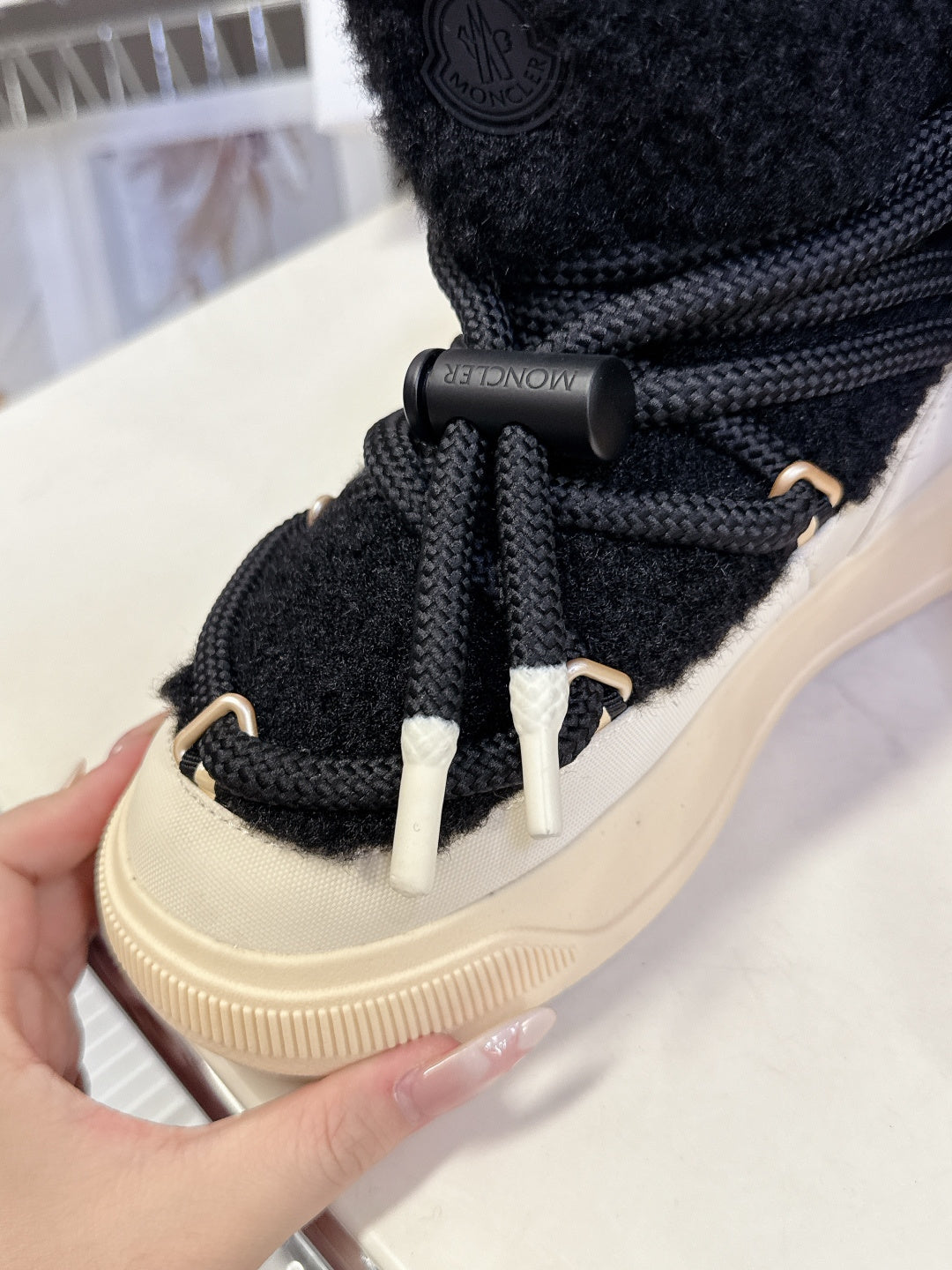 Moncler luxury shoes: black lace-up boot detail with metal lace tips and cream sole