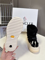 Moncler luxury shoes: outsole view of black sherpa boot with cream sole, single shoe