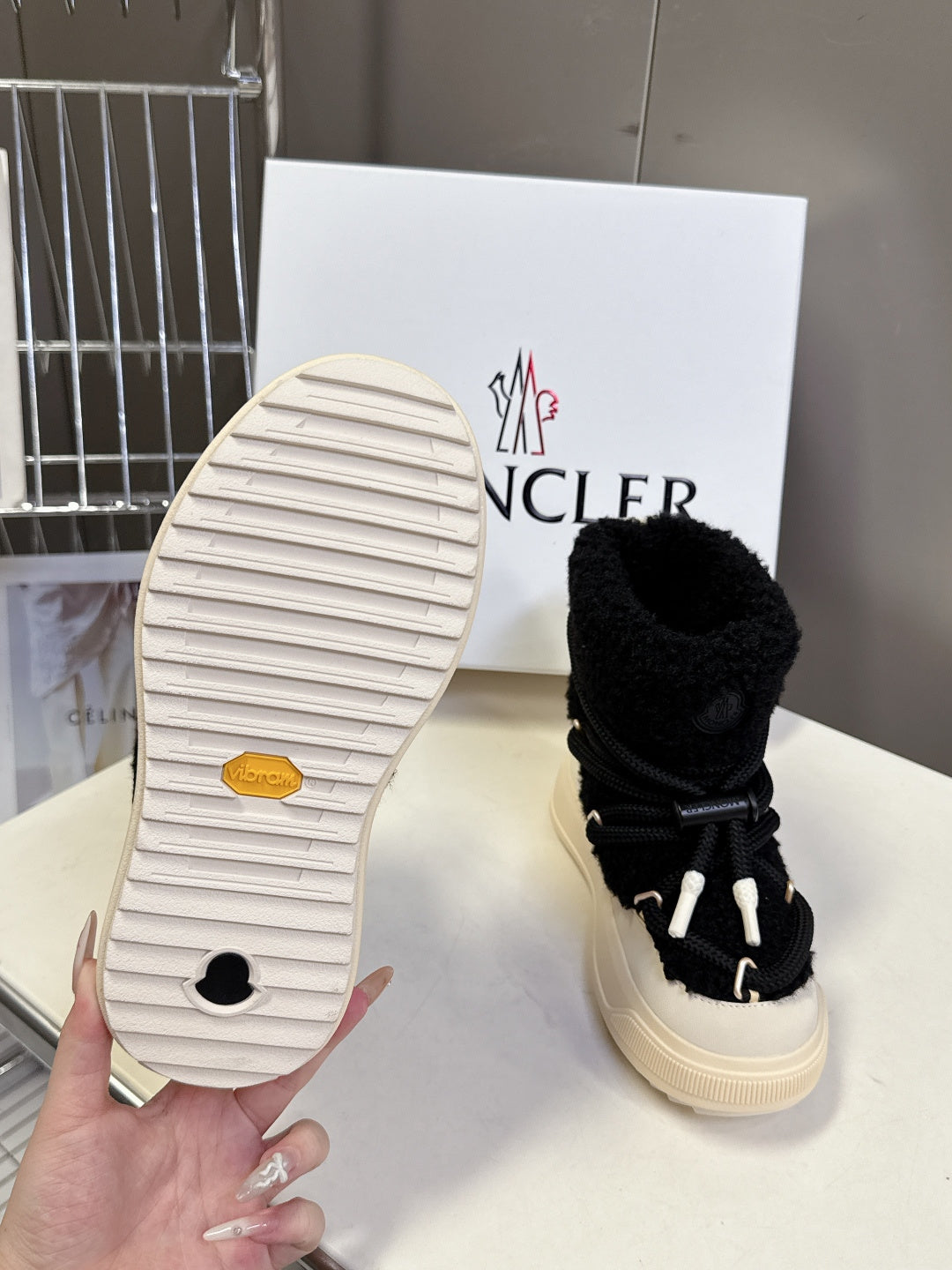 Moncler luxury shoes: outsole view of black sherpa boot with cream sole, single shoe