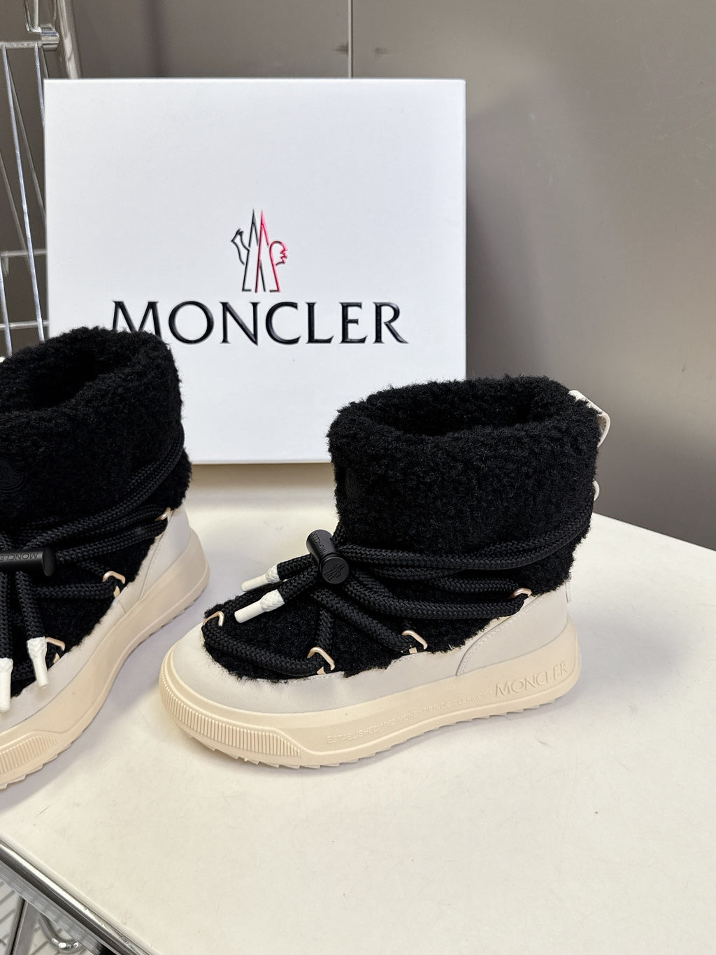 Moncler luxury shoes: black sherpa booties with lace-up front and cream rubber sole