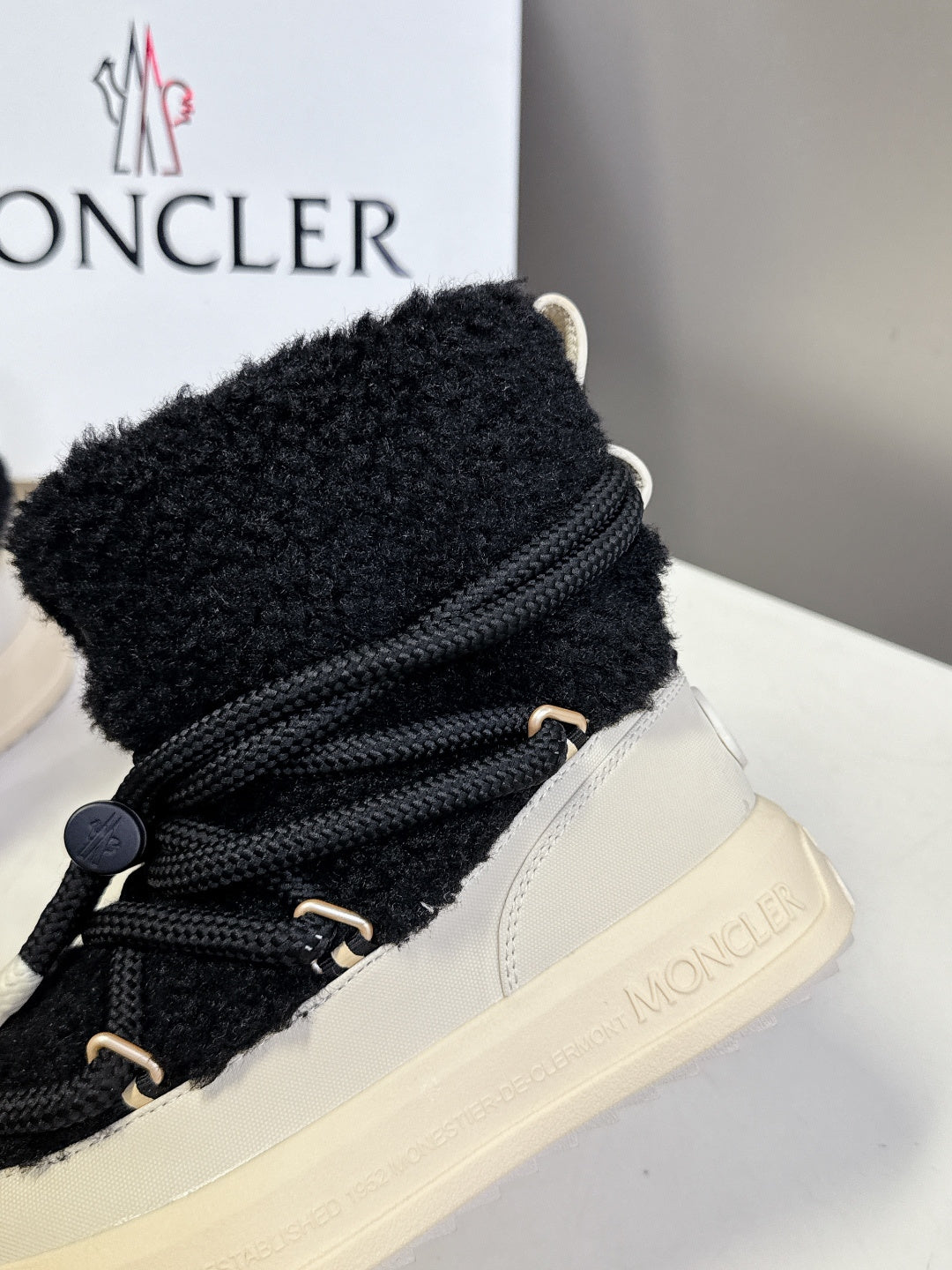 Moncler luxury shoes: black sherpa high-top with laces and cream trim, close-up