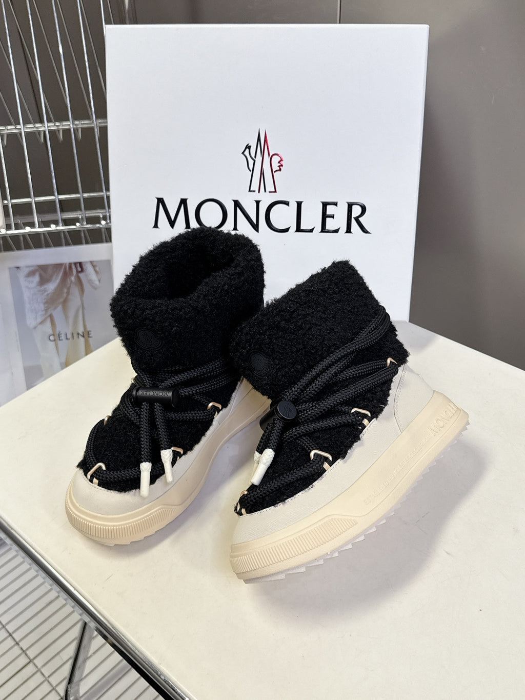 Moncler luxury shoes: black sherpa lace-up boots with cream platform, front view