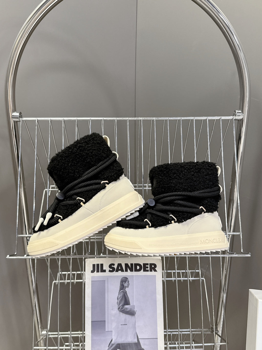 Moncler luxury shoes: black sherpa boots with lace-up design and cream soles, shelf