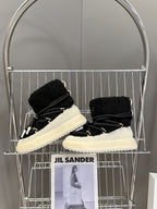 Moncler luxury shoes: black sherpa boots with lace-up design and cream soles, shelf