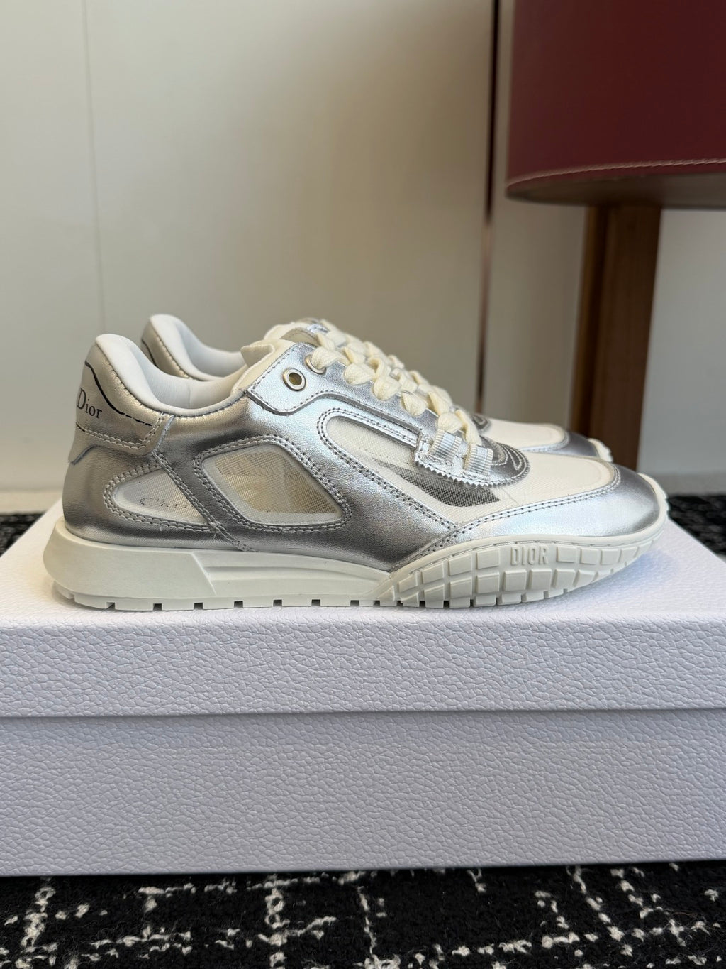 Silver-and-white Dior low-top sneakers, side view with laces and padded collar