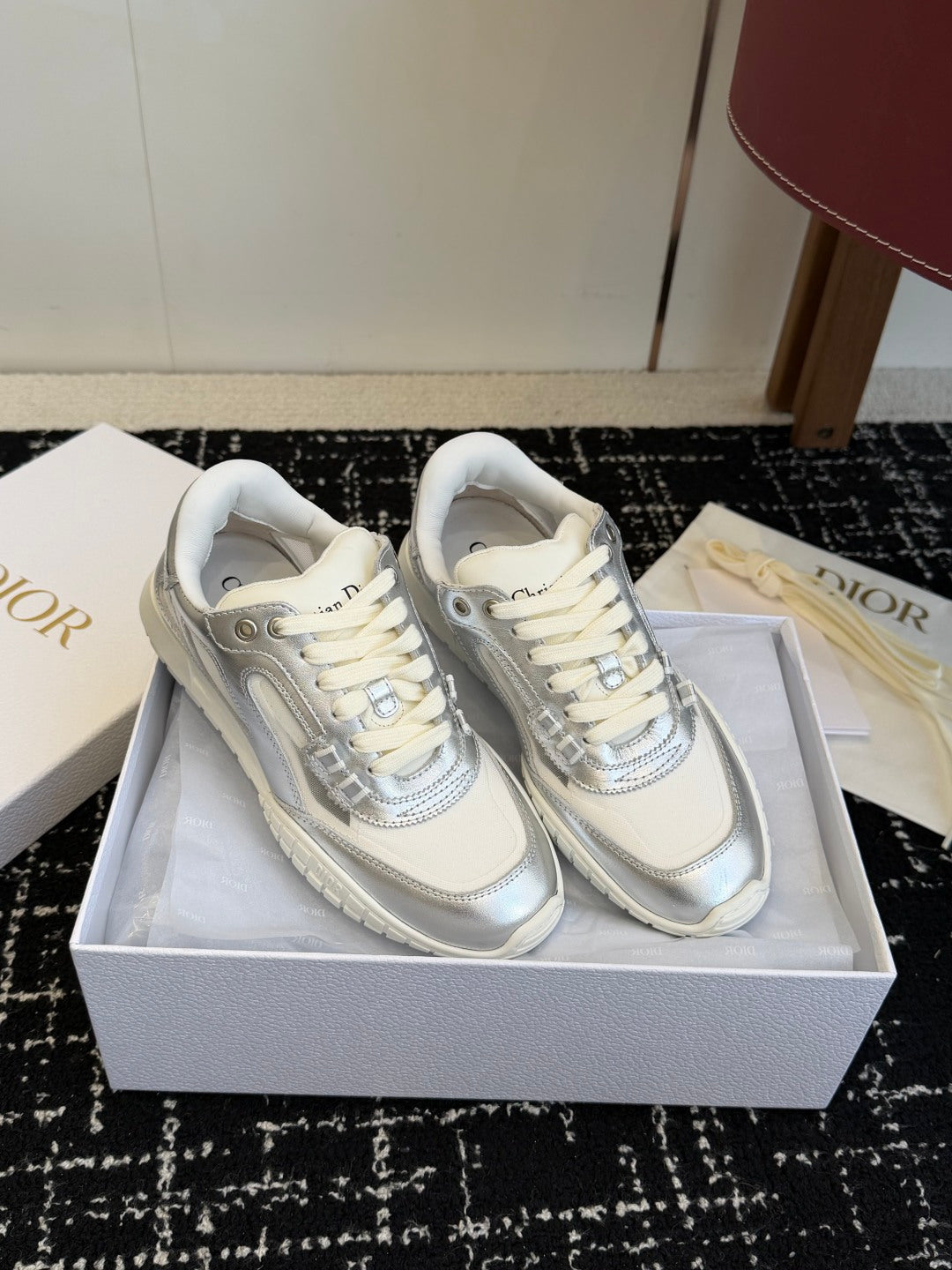 White Dior low-top sneakers on box, pair with lace-up fronts