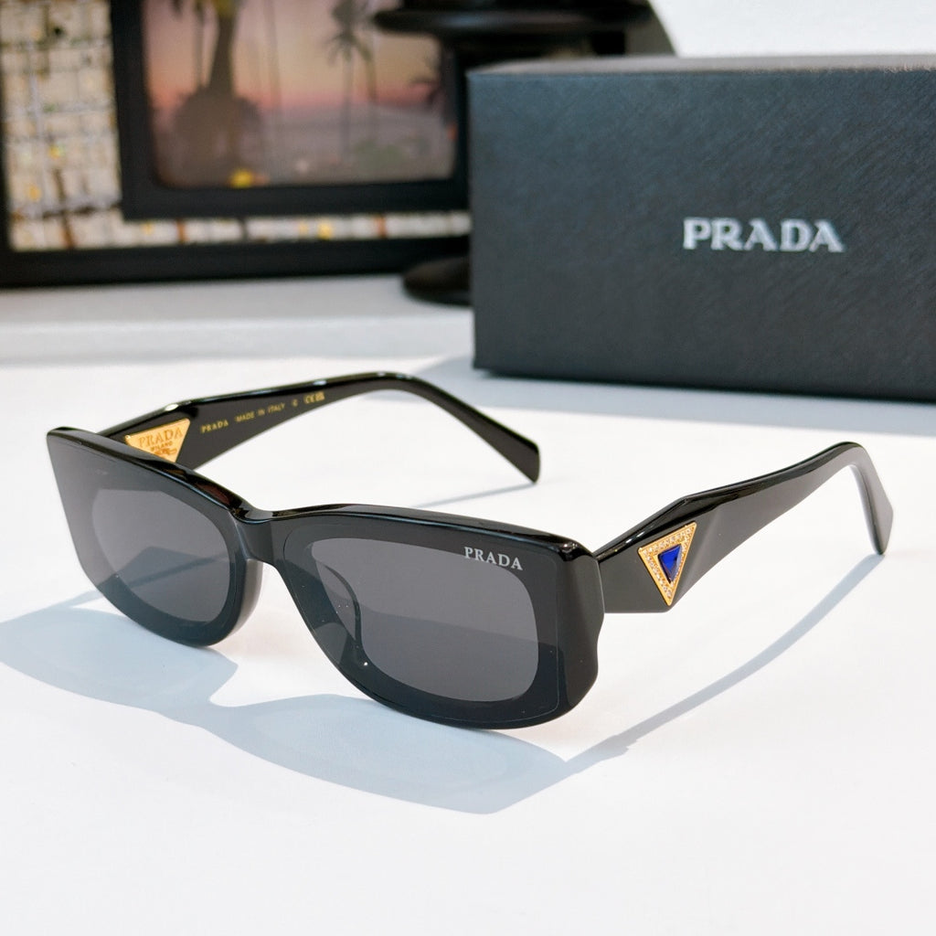 Sunglasses with dark green frame and gray lenses, gold triangle logo on temple arms.