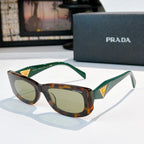 Sunglasses with green temples, tortoiseshell center, tinted lenses, gold triangle logo at sides.