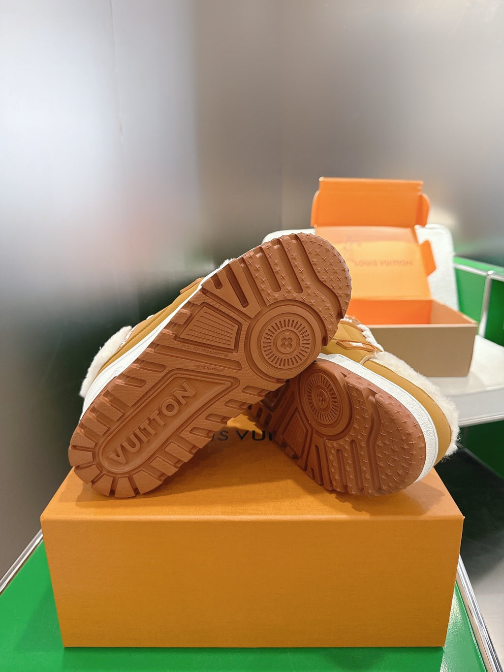 Unisex sneaker outsoles: brown rubber tread and white edge trim on a box