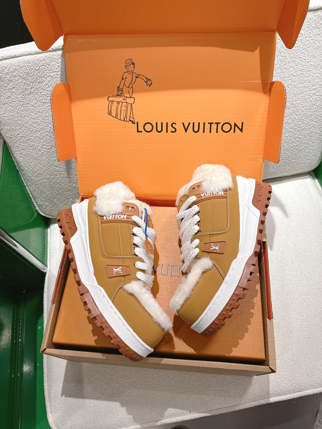 Unisex tan sneakers with white laces and fluffy fur lining in an open gift box