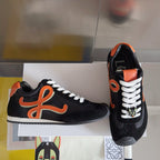 Unisex black sneakers with orange emblem, white laces, and patterned side detail