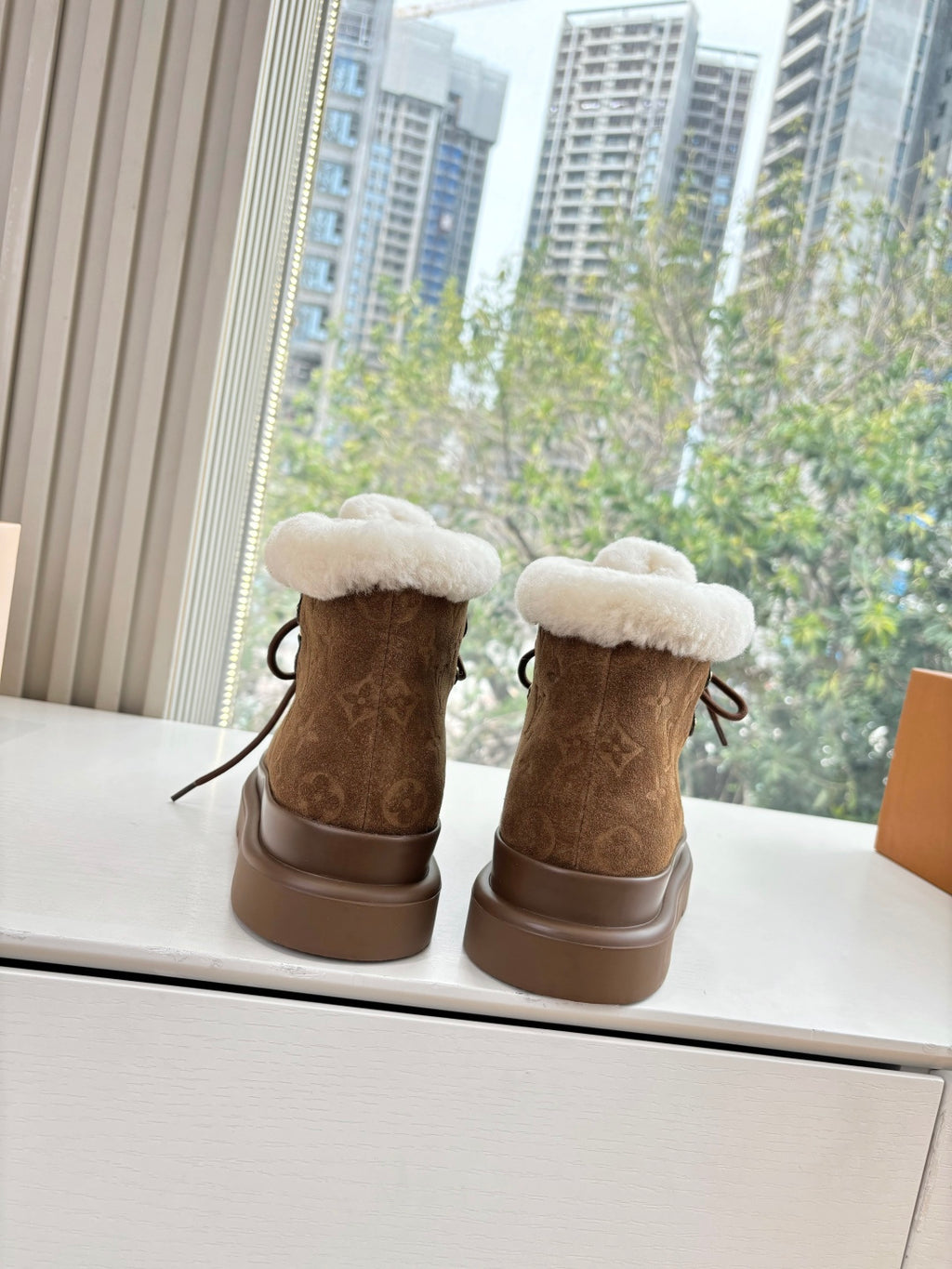 Louis Vuitton lace-up ankle boots, brown with rear shearling lining and chunky sole.