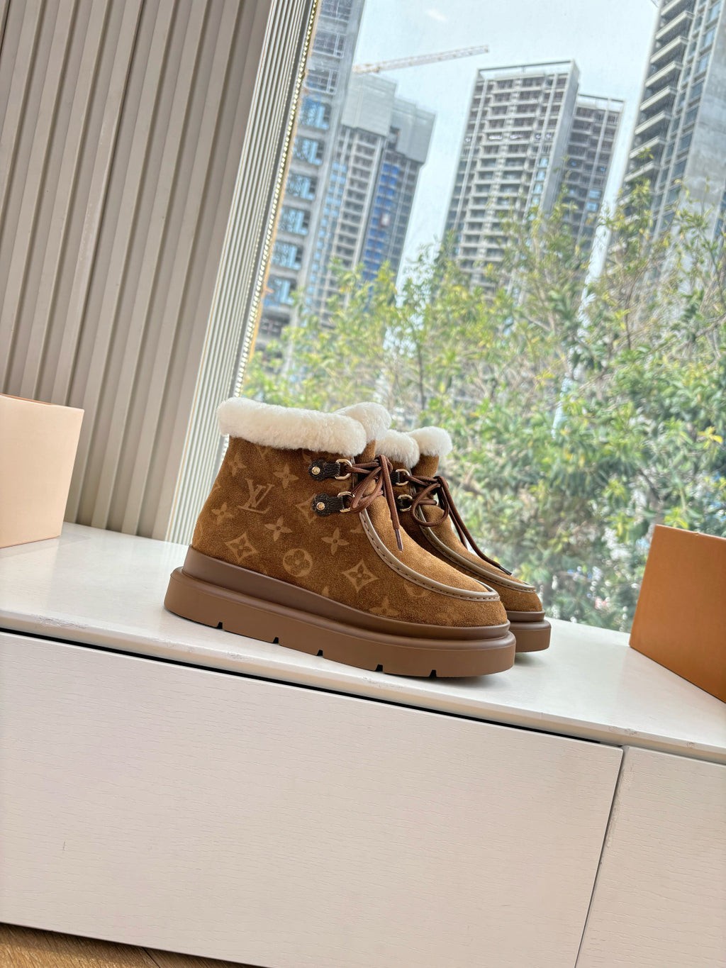 Louis Vuitton lace-up ankle boots, brown monogram with white shearling collar.