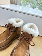 Louis Vuitton lace-up ankle boots, brown monogram suede with white shearling tongue.