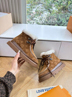 Louis Vuitton lace-up ankle boots with white shearling cuff, brown monogram upper.