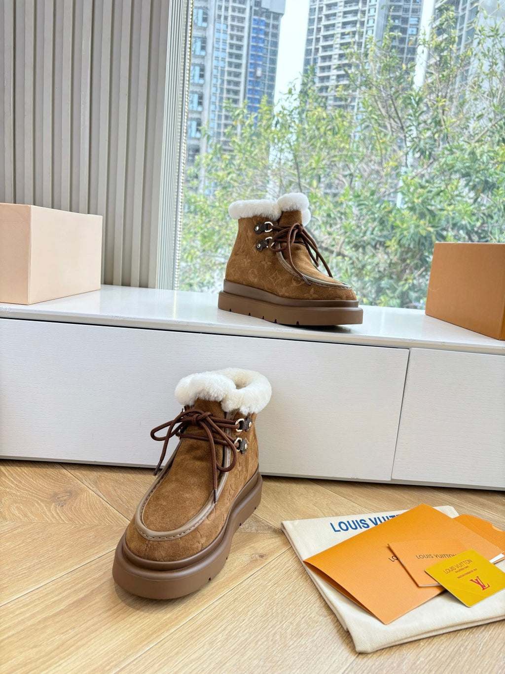 Louis Vuitton lace-up ankle boots, brown monogram with white shearling top and laces.