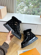 Unisex Louis Vuitton black monogram lace-up boots with faux fur trim, angled view