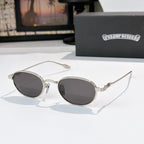 Round sunglasses with dark lenses and silver metal frame, decorative temple arms.