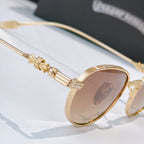 Gold sunglasses temple detail with engraved floral accents and tinted lens edge.