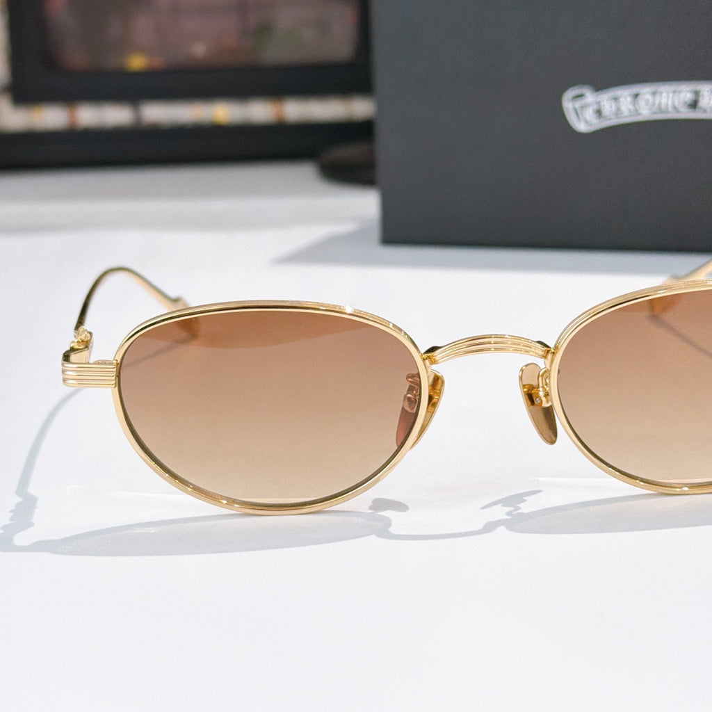 Gold round sunglasses with tinted lenses and curved temple hinges, side view.