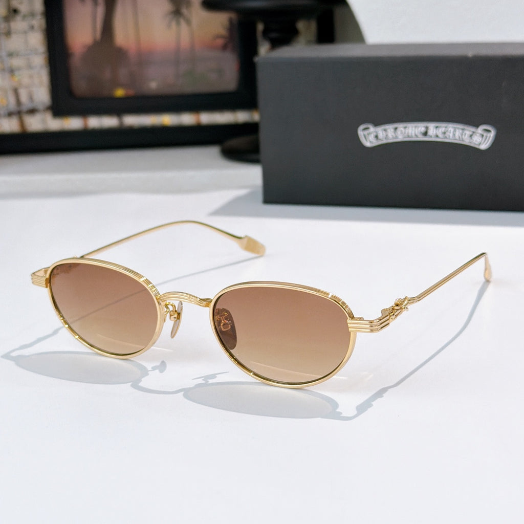 Round sunglasses with brown lenses and gold metal frame, decorative temple arms.